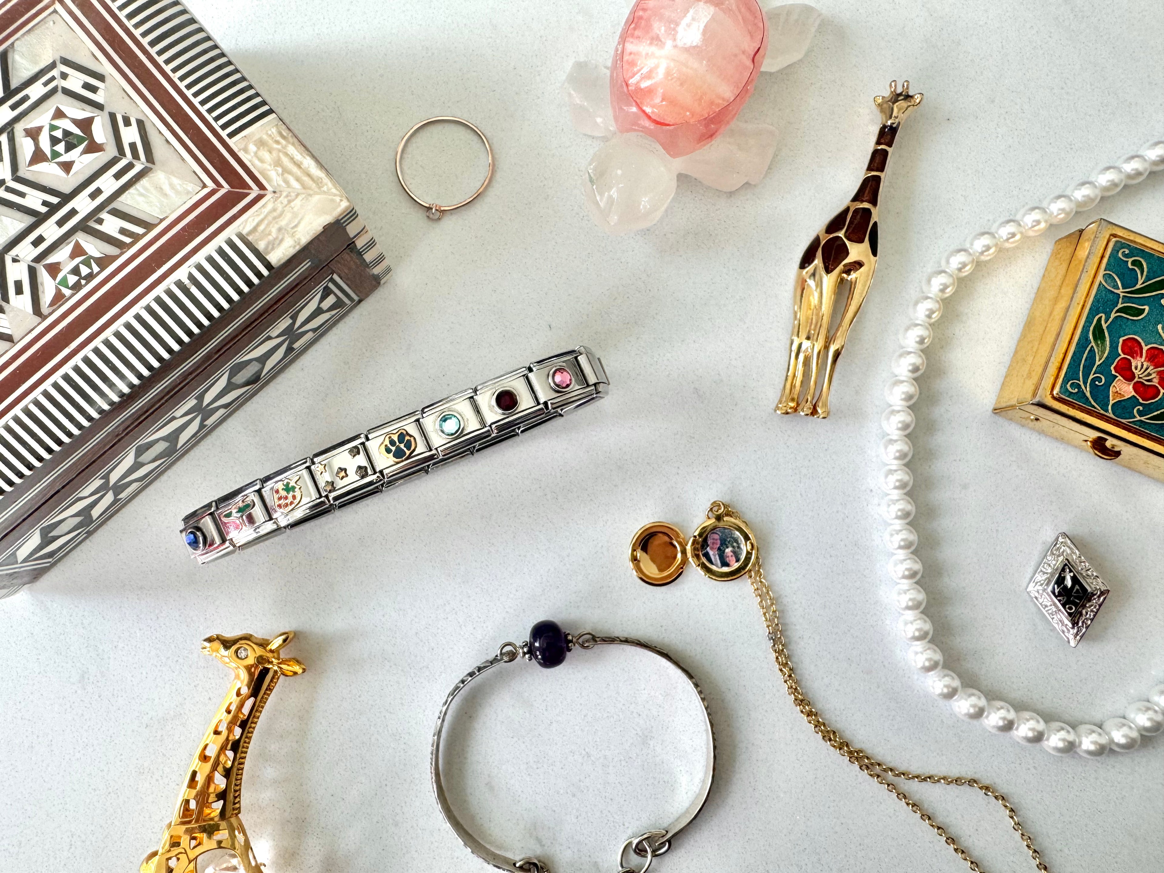 Collection of jewelry including a bracelet, earrings, and necklaces on a marble surface.