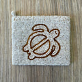 Vintage white iridescent seed bead coin purse with gold bead sea turtle motif on a light wood surface