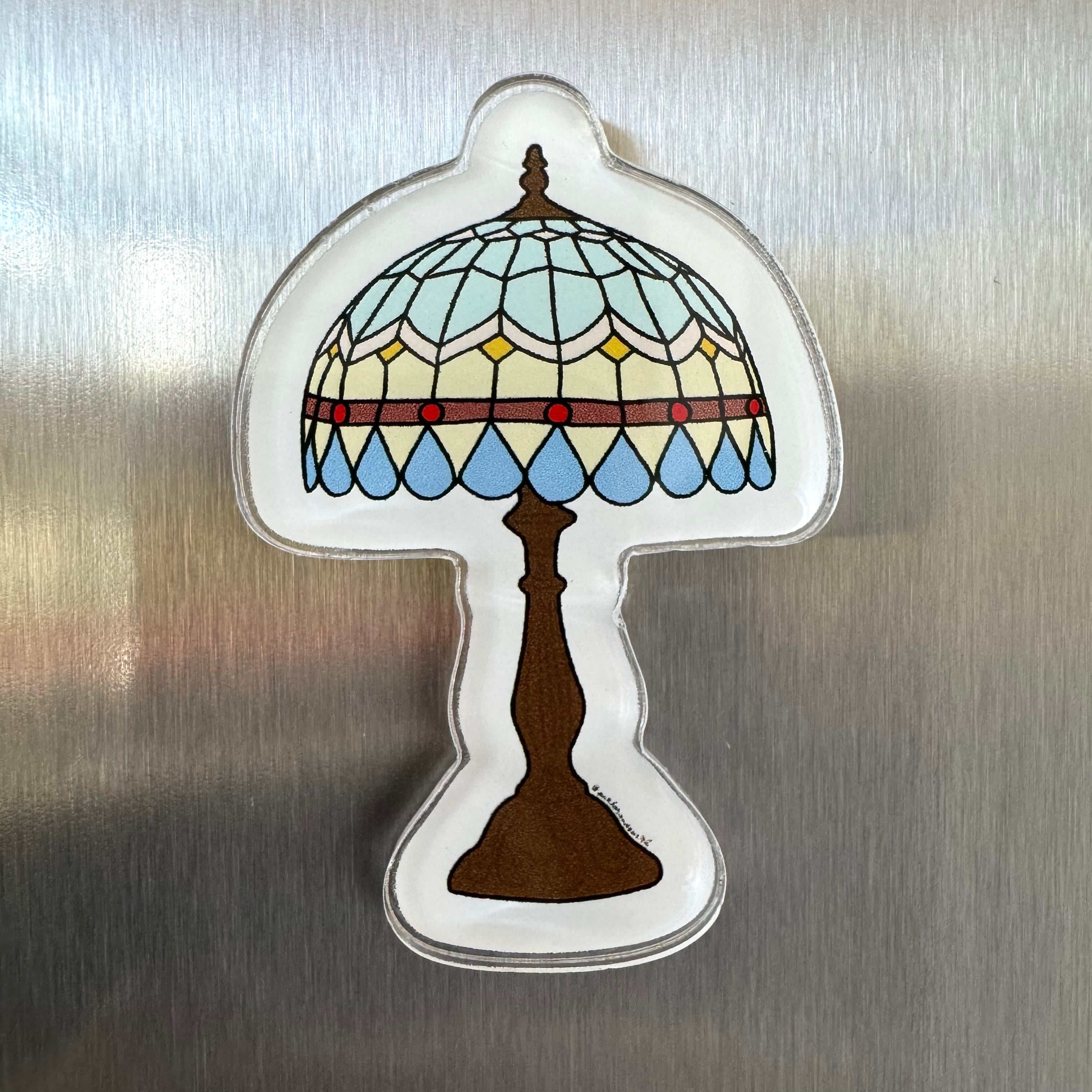 Acrylic magnet featuring a Tiffany-style stained glass lamp with light blue panels and hanging blue teardrop details